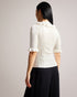 KATELLA-Knitwear-Made of stretchy knit, KATELLA is the perfect statement top to take you from season to season in style. With an oh-so-cute ruffle trim and a super soft feel, this fitted top is sure to become your new go-to. Ted Baker womenswear collection Fitted top Stretch fabric High neck Neck ruffle Ribbed knit Short sleeves with ruffle trim Amy is 5'9.5" / 1.77m and wears Black in a Ted size 1- Ted Baker Romania